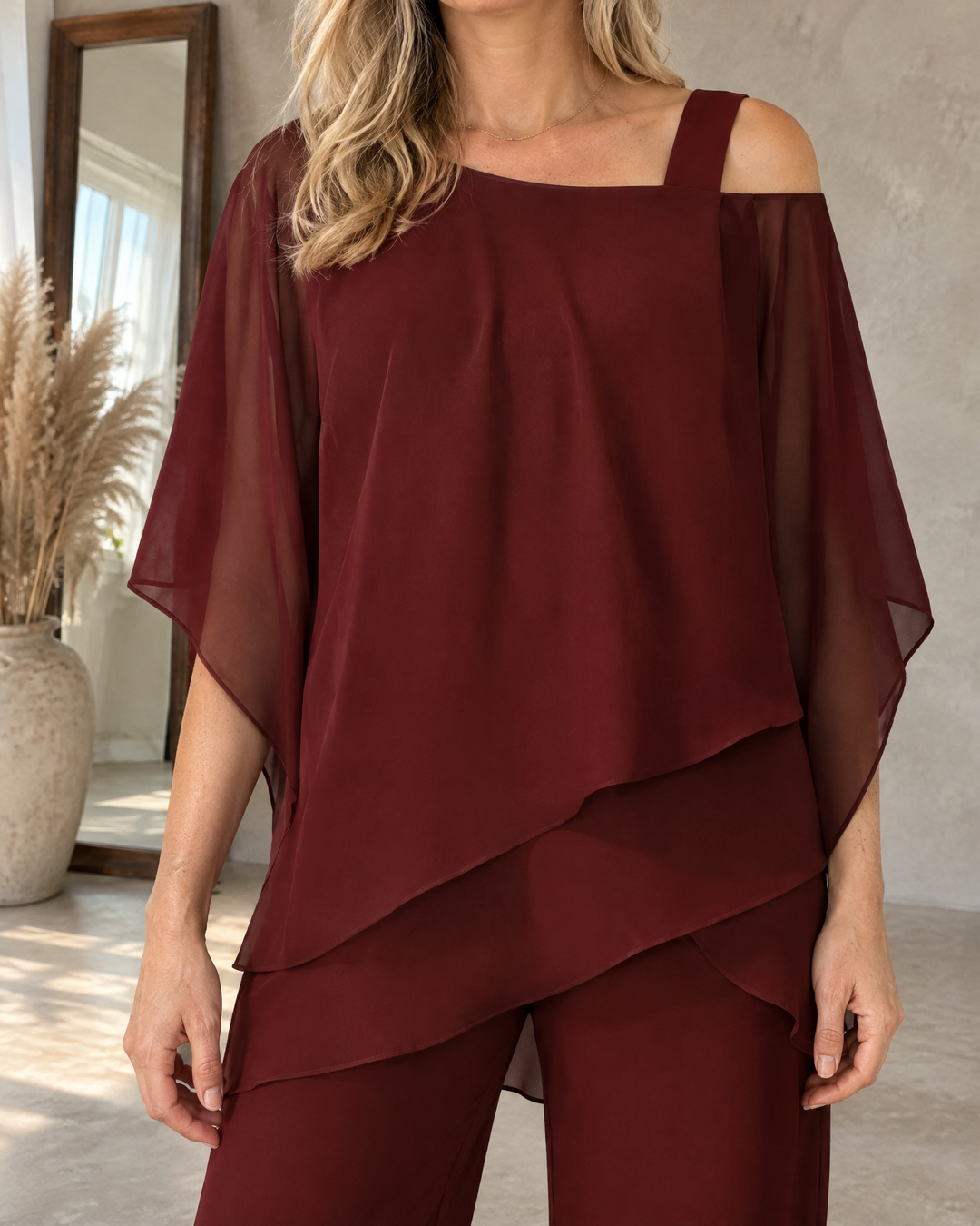 Isaure - Batwing Asymmetric Set in burgundy, detail of the strap, the sheer sleeve and the layered hem