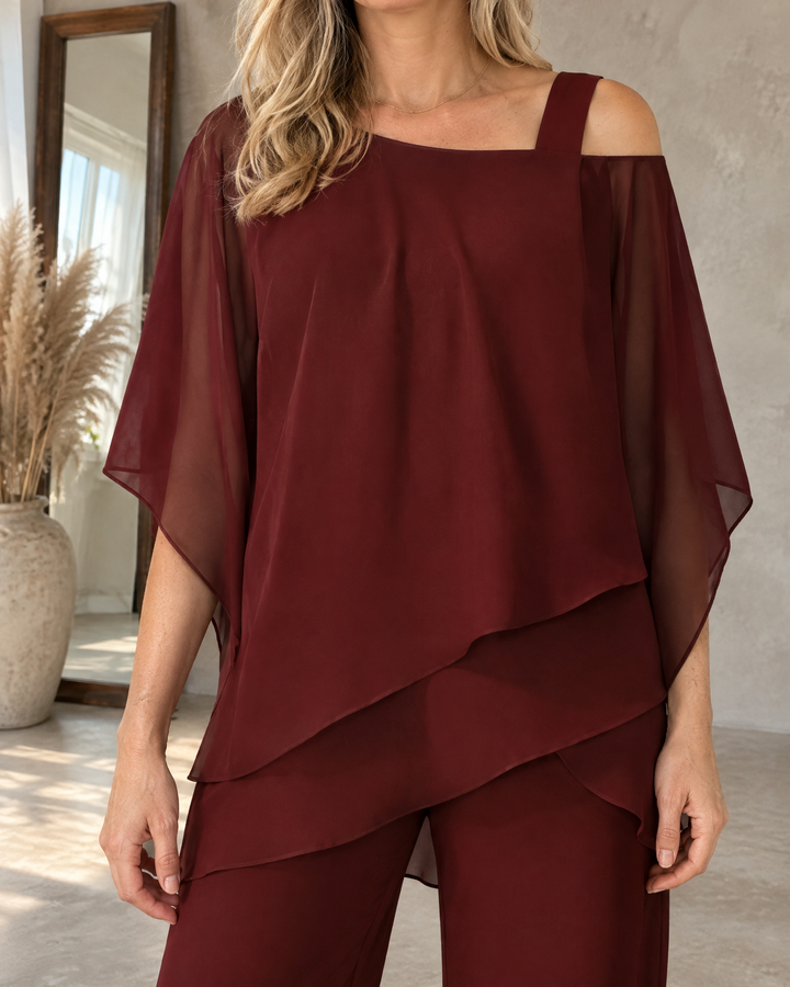 Isaure - Batwing Asymmetric Set in burgundy, detail of the strap, the sheer sleeve and the layered hem