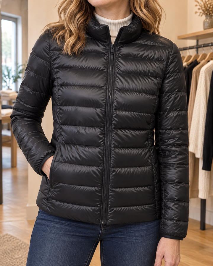 Aline - Lightweight Down Jacket in black, detail of the stand collar, the zip and the stitched channels