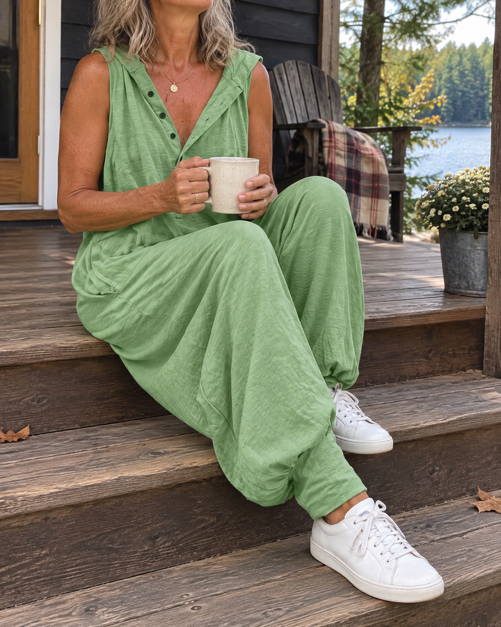 Gabrielle - Hooded Button Jumpsuit in sage green, on a cottage porch