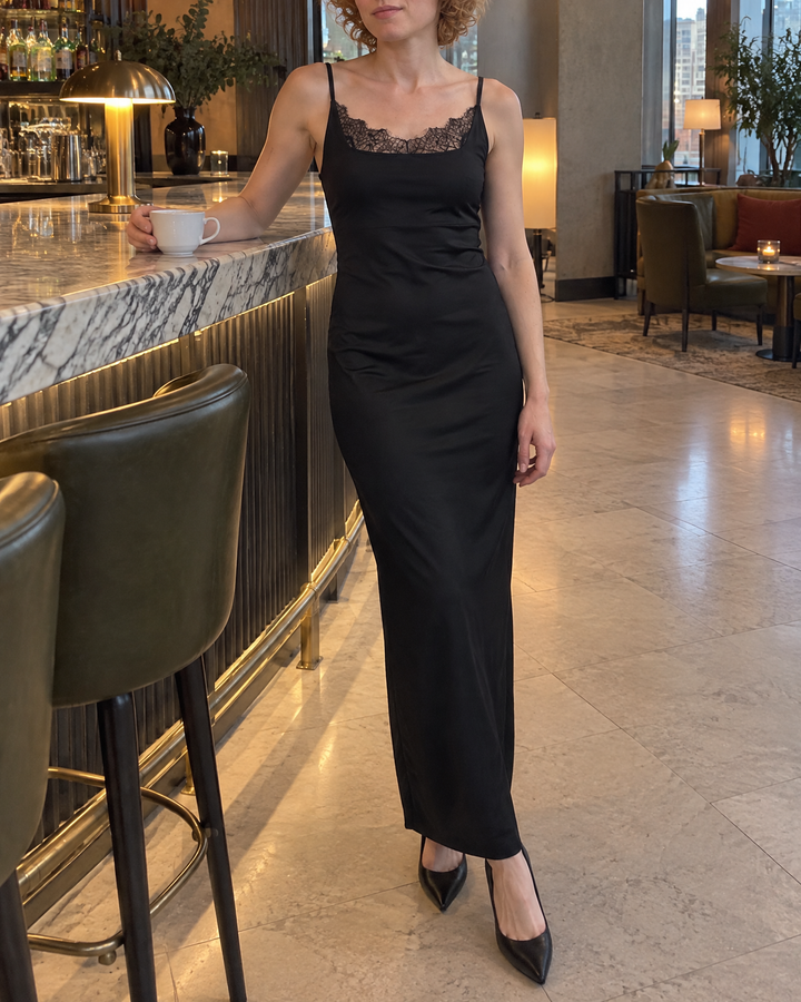 Heloise - Lace Trim Satin Slip Dress in black, in a hotel lounge