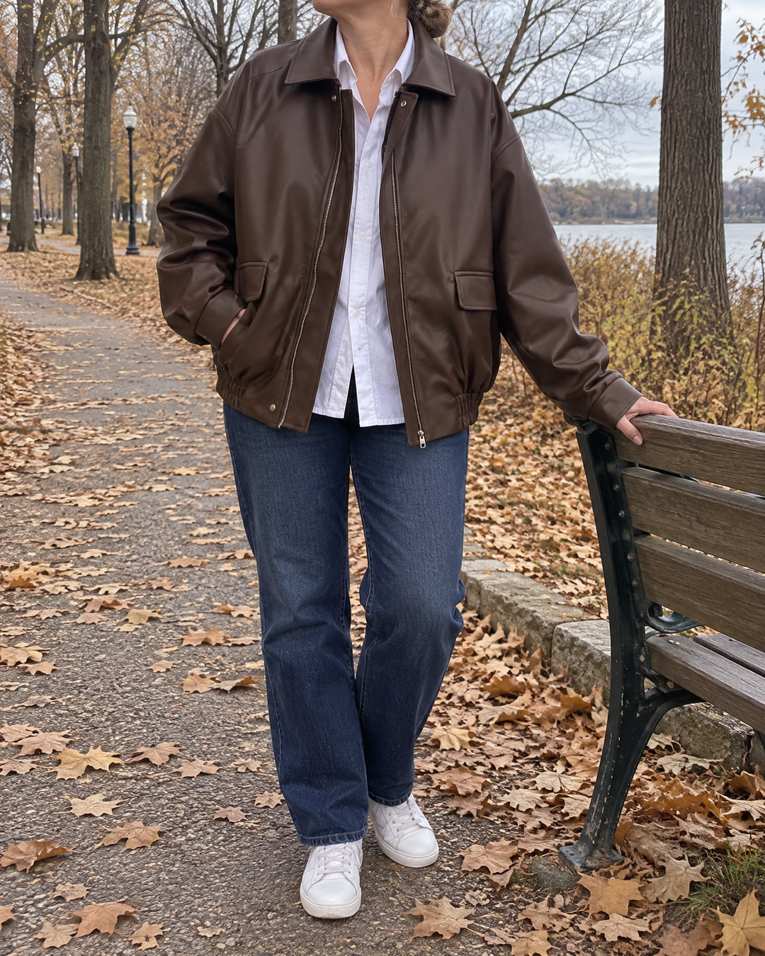 Leontine - Oversized Faux Leather Bomber in brown, in the park on a cloudy afternoon