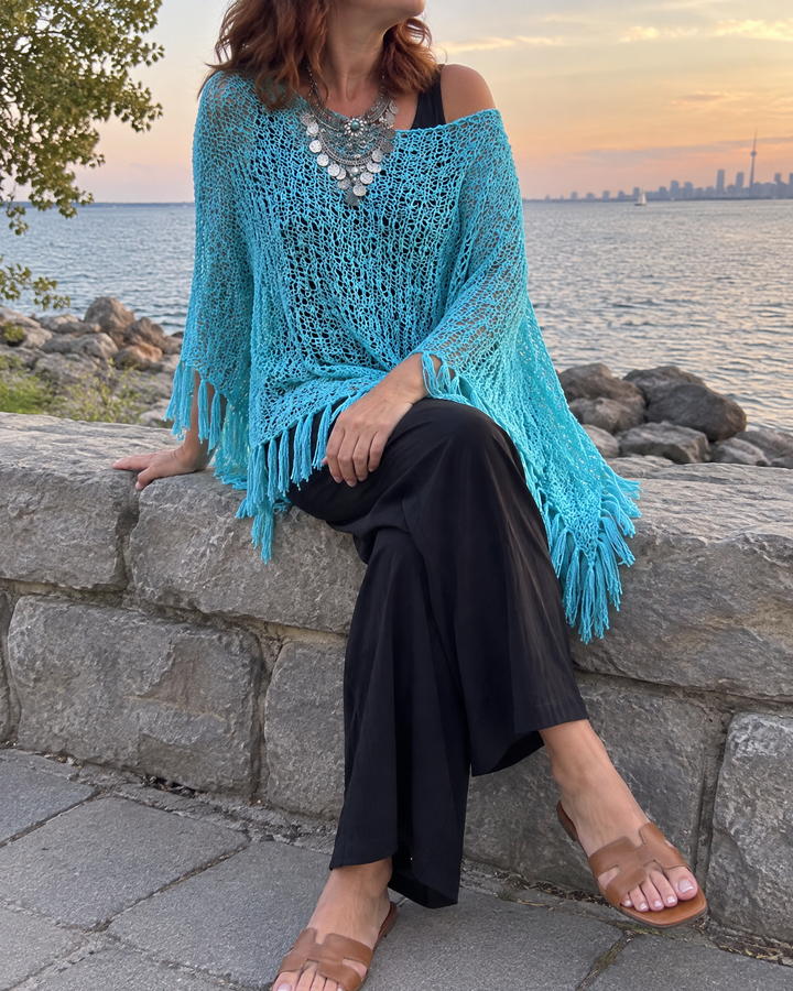 Oceane - Open Knit Tassel Poncho in turquoise, by the lake