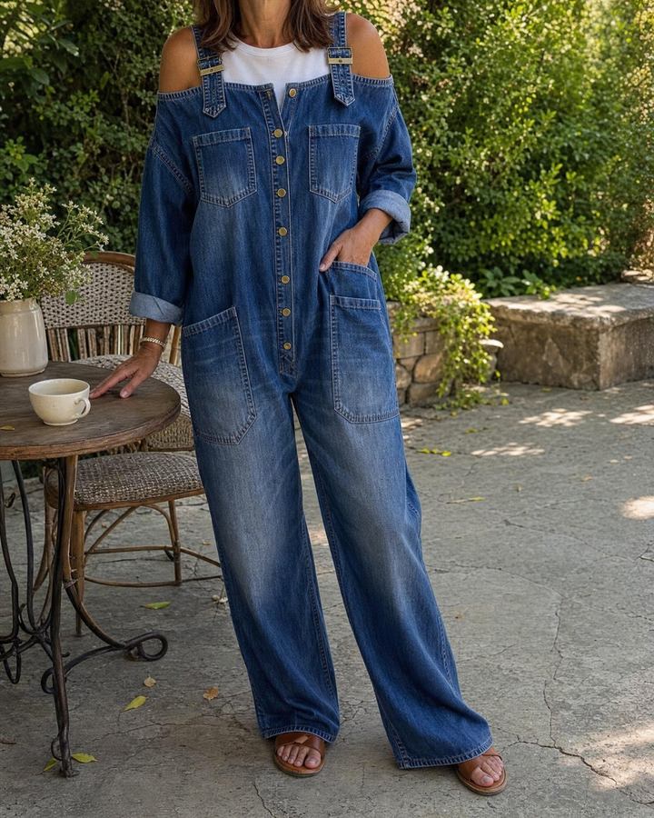 Margot - Denim Jumpsuit in denim blue, worn on a garden terrace
