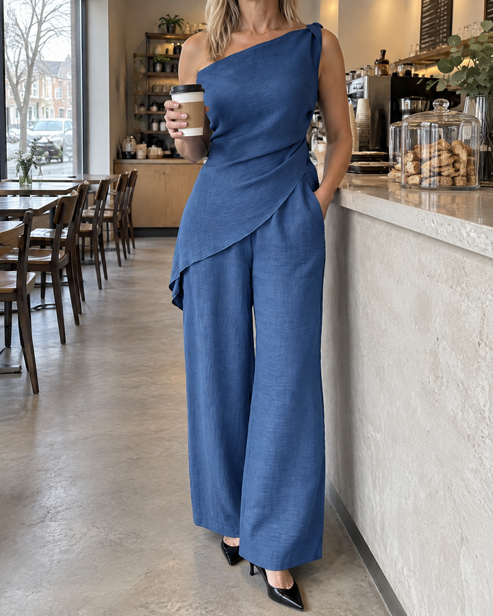 Daphne - One-Shoulder Draped Set in blue, picking up a coffee on a weekday morning