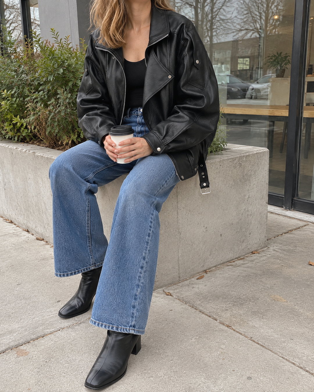 Mirabelle - Oversized Faux Leather Biker Jacket in black, with a coffee on a cloudy afternoon
