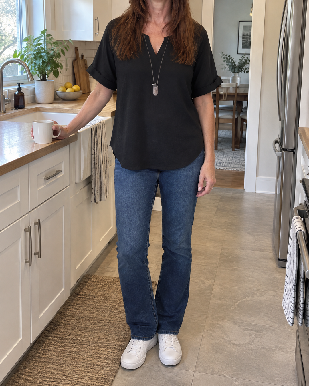 Elodie - Relaxed V-Neck Blouse in black, worn in a kitchen