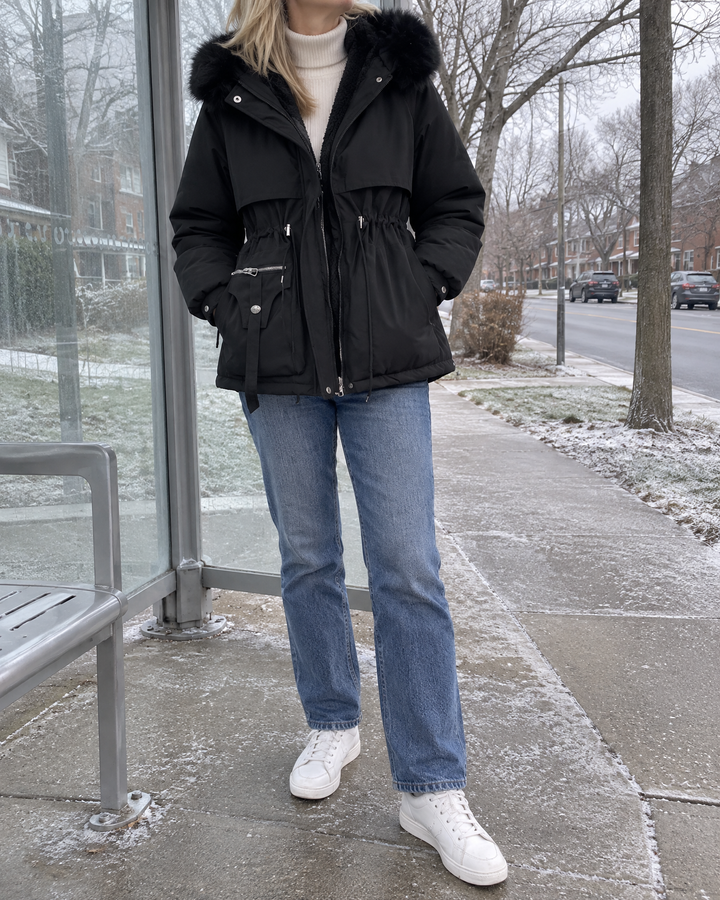 Brigitte - Faux Fur Hooded Parka in black, on a cold grey morning, waiting for the bus