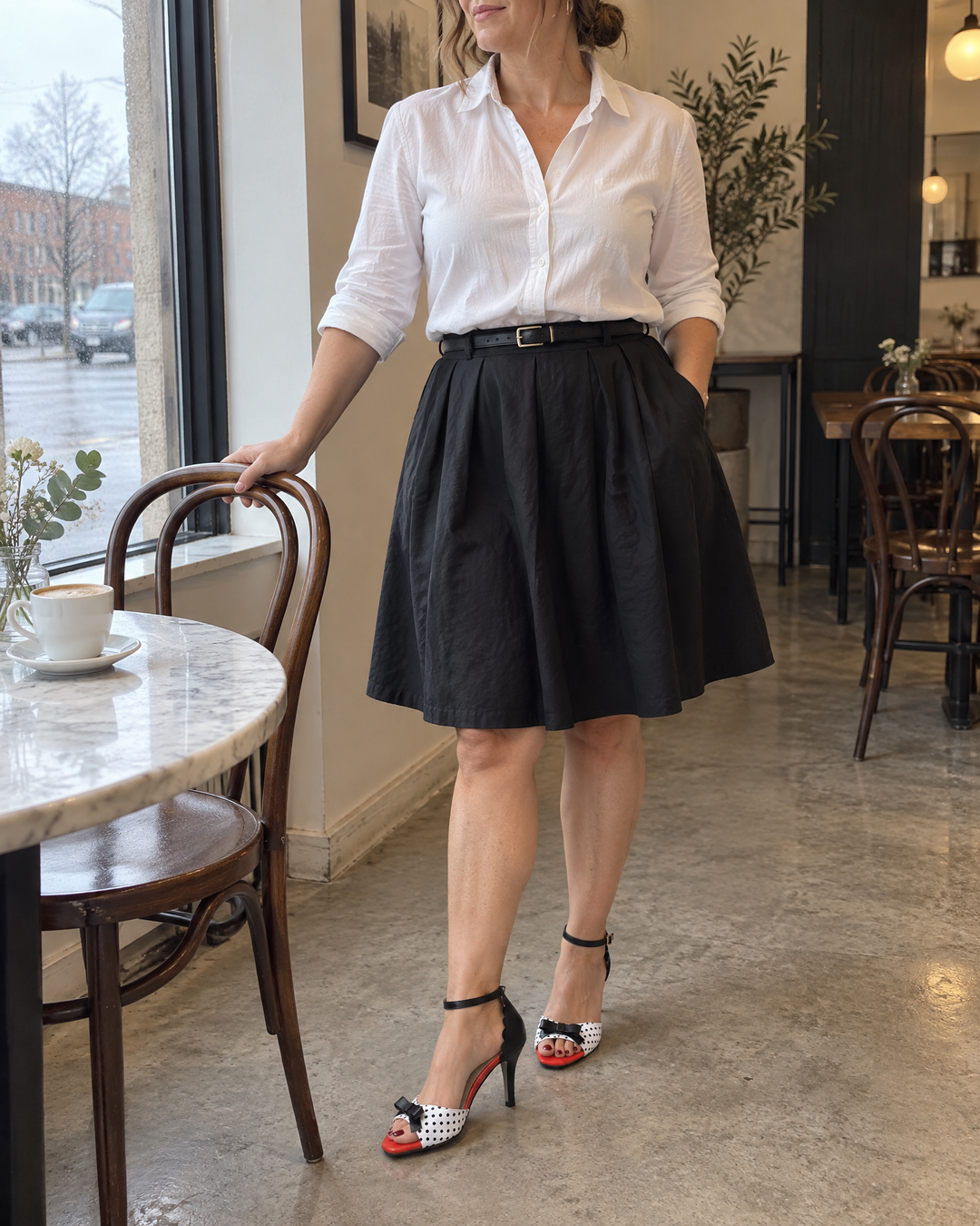 Yolande - Polka Dot Bow Sandals in white, by a café window