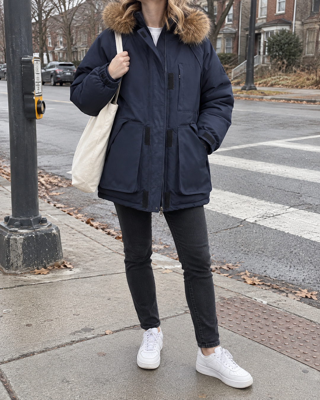 Francine - Oversized Hooded Parka in navy, crossing a quiet street on a cold morning