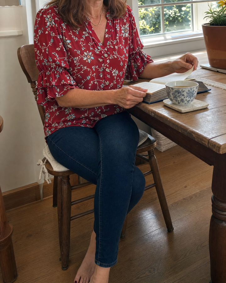 Vivienne - Vintage Print Blouse in red, worn at a kitchen table