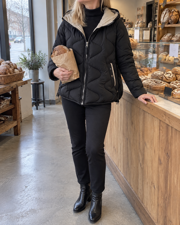 Carole - Wave Quilted Hooded Jacket in black, fresh bread on a grey morning