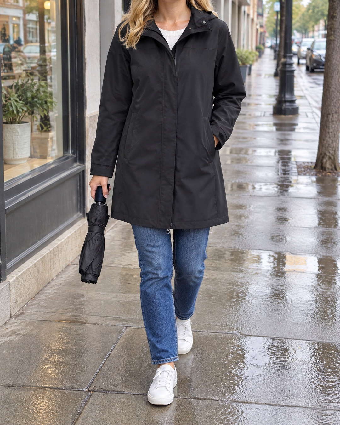 Jacqueline - Water-Repellent Hooded Coat in black, a city sidewalk after a shower