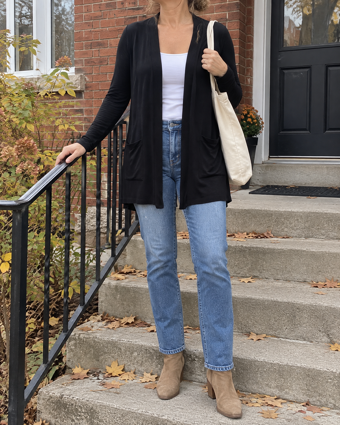 Nicolette - Longline Pocket Cardigan in black, on the front steps on an overcast afternoon