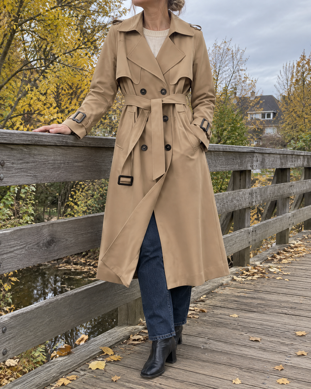 Monique - Long Belted Trench Coat in khaki, on a footbridge on a grey October morning