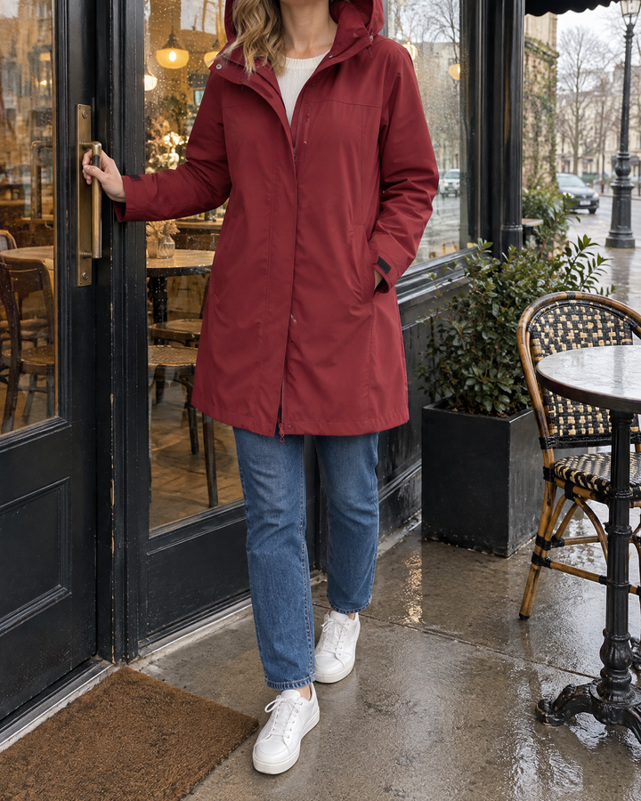 Jacqueline - Water-Repellent Hooded Coat in wine, under a café awning on a drizzly afternoon