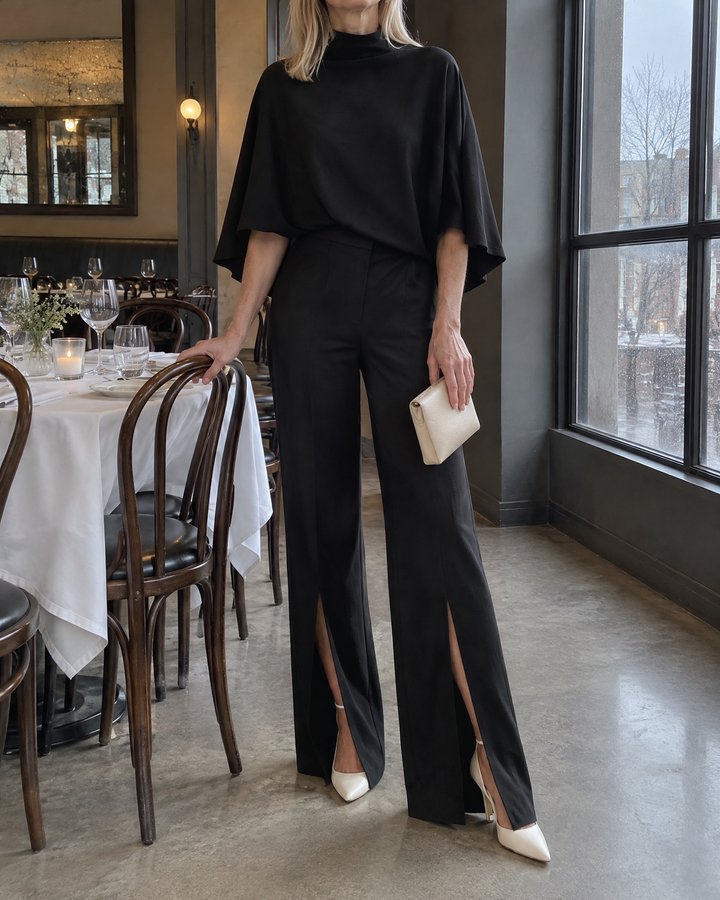 Cecile - Mock-Neck Cape Top Set in black, at a restaurant table in the evening