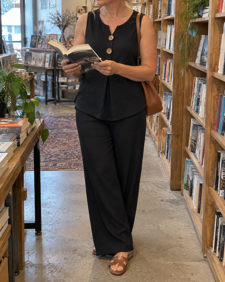 Paloma - Sleeveless Button Top Set in black, browsing a bookshop on a grey afternoon
