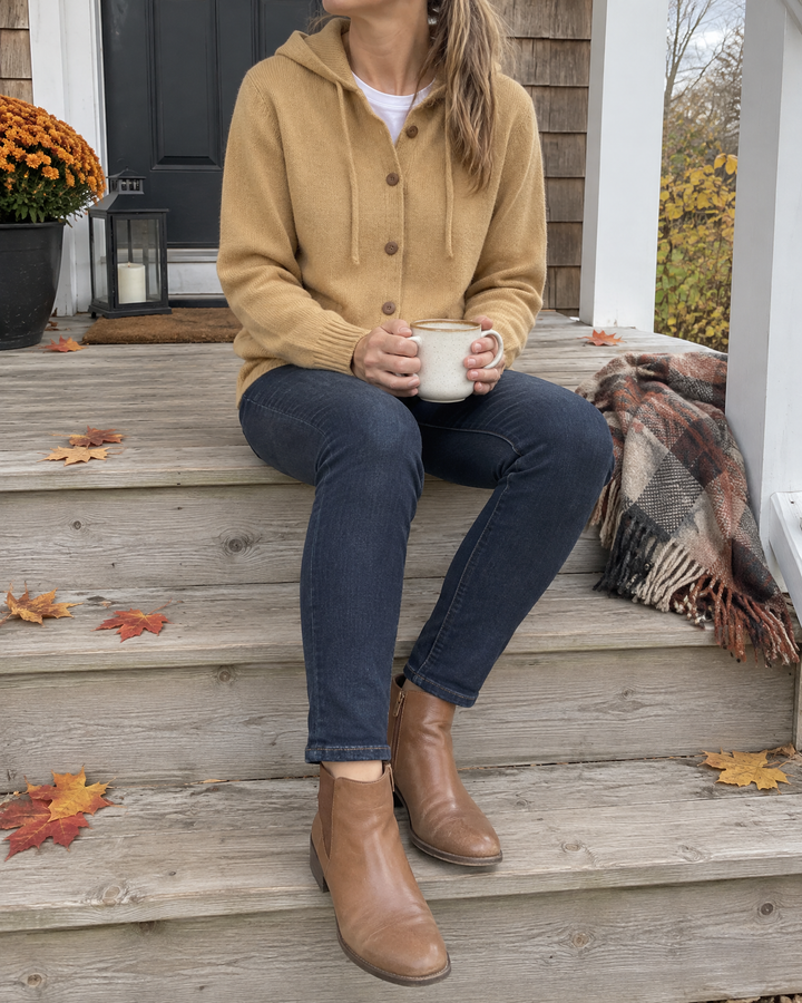 Greta - Hooded Knit Cardigan in khaki, worn on a cottage porch