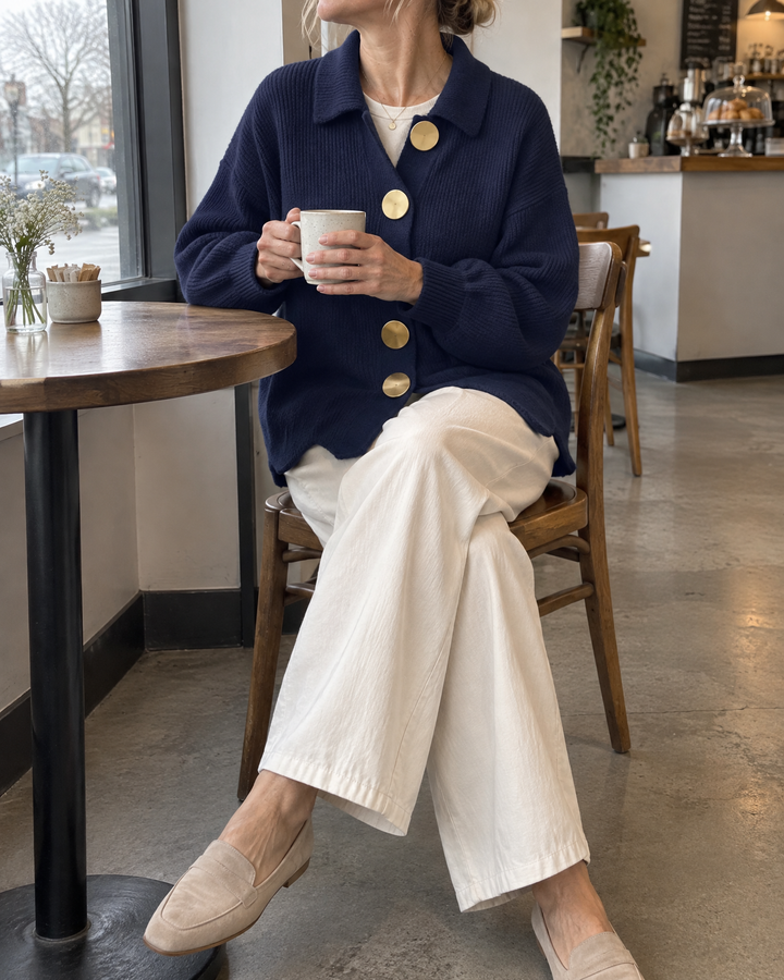 Albane - Collared Button Cardigan in navy, at a cafe table with a coffee